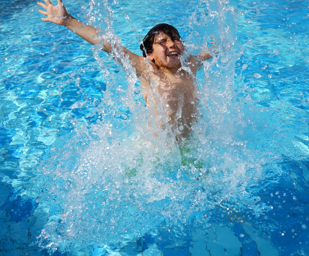 Happy little boys enjoying relaxing and splashing in water